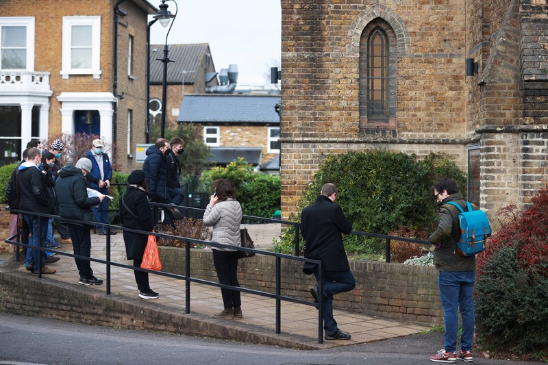 HEALTH-CORONAVIRUS/BRITAIN People queue outside a coronavirus disease (COVID-19) vaccination centre at a church in London, Britain, December 13, 2021. REUTERS/Hannah McKay