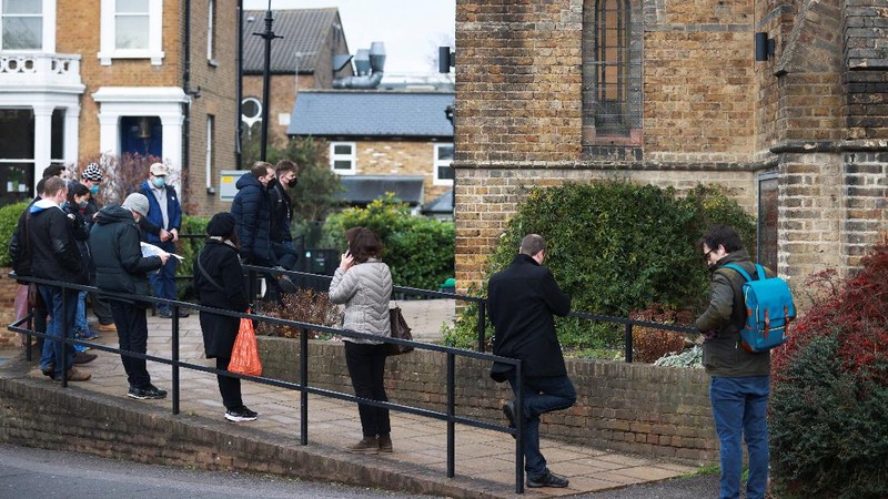 People queue outside a coronavirus disease (COVID-19) vaccination centre at a church in London, Britain, December 13, 2021. REUTERS/Hannah McKay