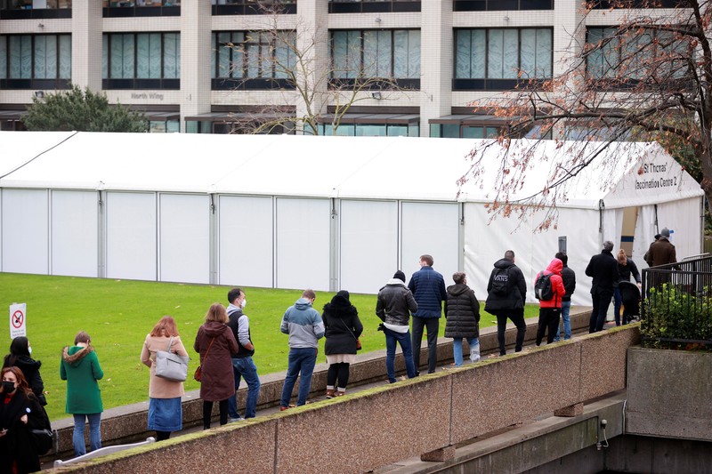 HEALTH-CORONAVIRUS/BRITAIN People queue outside a coronavirus disease (COVID-19) vaccination centre at a church in London, Britain, December 13, 2021. REUTERS/Hannah McKay