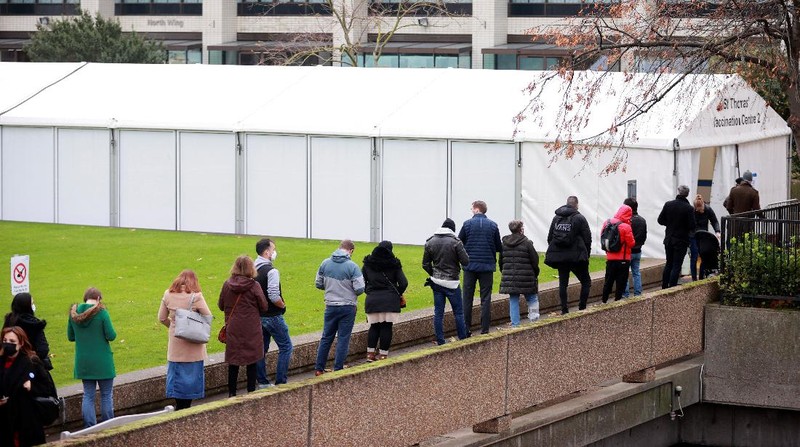 People queue outside a coronavirus disease (COVID-19) vaccination centre at a church in London, Britain, December 13, 2021. REUTERS/Hannah McKay