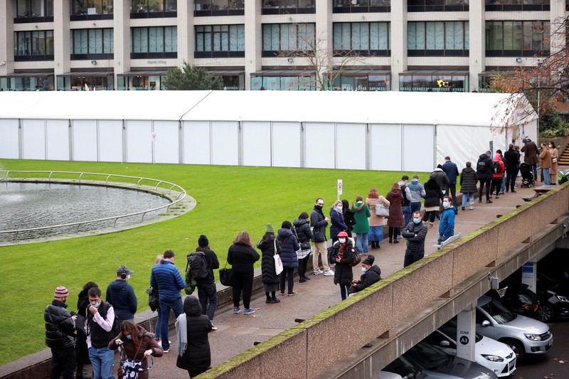 People queue outside a coronavirus disease (COVID-19) vaccination centre at a church in London, Britain, December 13, 2021. REUTERS/Hannah McKay