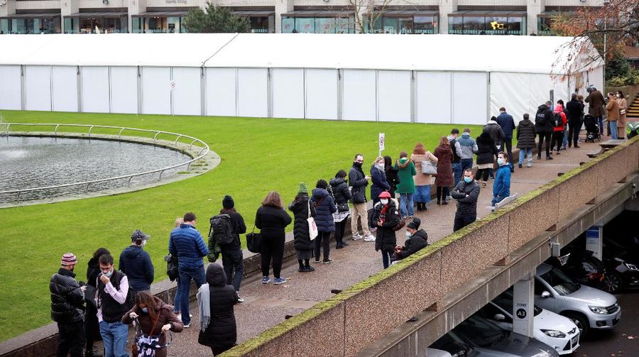 People queue outside a coronavirus disease (COVID-19) vaccination centre at a church in London, Britain, December 13, 2021. REUTERS/Hannah McKay
