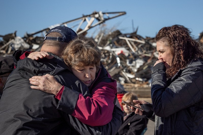 USA-WEATHER/TORNADOES Local residents Darlene Easterwood and Tim Evans embrace after taking part in an outdoor Sunday service with members of First Christian Church and First Presbyterian Church in the aftermath of a tornado in Mayfield, Kentucky, U.S. December 12, 2021. Both churches were left extensively damaged. REUTERS/Adrees Latif