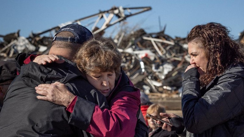 Local residents Darlene Easterwood and Tim Evans embrace after taking part in an outdoor Sunday service with members of First Christian Church and First Presbyterian Church in the aftermath of a tornado in Mayfield, Kentucky, U.S. December 12, 2021. Both churches were left extensively damaged. REUTERS/Adrees Latif