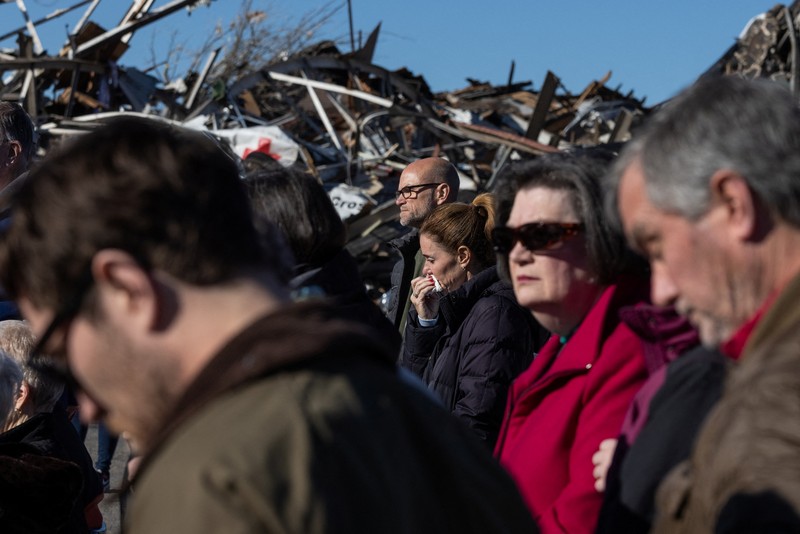 USA-WEATHER/TORNADOES Local residents Darlene Easterwood and Tim Evans embrace after taking part in an outdoor Sunday service with members of First Christian Church and First Presbyterian Church in the aftermath of a tornado in Mayfield, Kentucky, U.S. December 12, 2021. Both churches were left extensively damaged. REUTERS/Adrees Latif