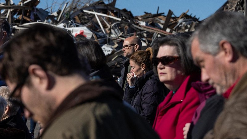 Local residents Darlene Easterwood and Tim Evans embrace after taking part in an outdoor Sunday service with members of First Christian Church and First Presbyterian Church in the aftermath of a tornado in Mayfield, Kentucky, U.S. December 12, 2021. Both churches were left extensively damaged. REUTERS/Adrees Latif