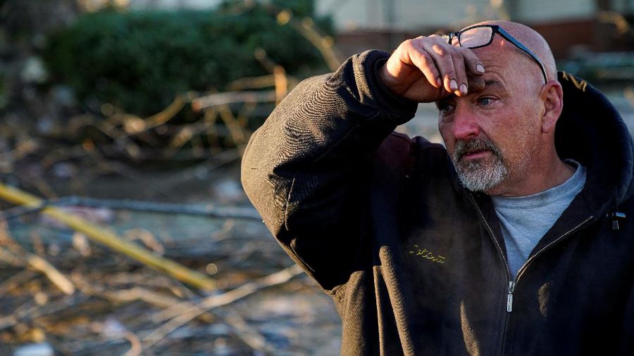 Local residents Darlene Easterwood and Tim Evans embrace after taking part in an outdoor Sunday service with members of First Christian Church and First Presbyterian Church in the aftermath of a tornado in Mayfield, Kentucky, U.S. December 12, 2021. Both churches were left extensively damaged. REUTERS/Adrees Latif