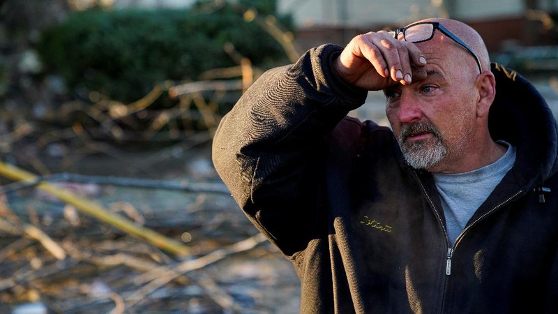 Local residents Darlene Easterwood and Tim Evans embrace after taking part in an outdoor Sunday service with members of First Christian Church and First Presbyterian Church in the aftermath of a tornado in Mayfield, Kentucky, U.S. December 12, 2021. Both churches were left extensively damaged. REUTERS/Adrees Latif