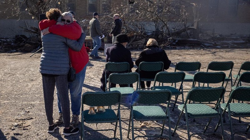 Local residents Darlene Easterwood and Tim Evans embrace after taking part in an outdoor Sunday service with members of First Christian Church and First Presbyterian Church in the aftermath of a tornado in Mayfield, Kentucky, U.S. December 12, 2021. Both churches were left extensively damaged. REUTERS/Adrees Latif