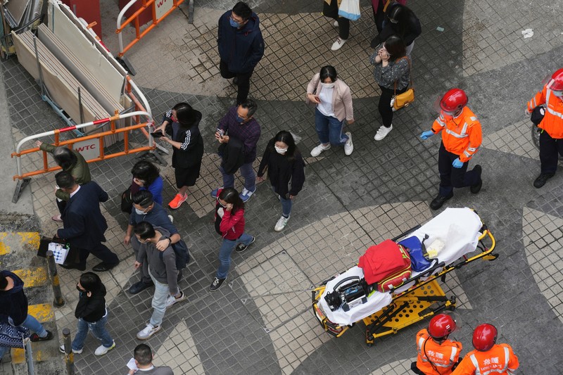 Kebakaran di gedung wtc Hong Kong Seorang petugas pemadam kebakaran menyelamatkan orang-orang yang terjebak dari kebakaran yang terjadi di World Trade Center di Hong Kong (15/12/2021). (REUTERS/Lam Yik)