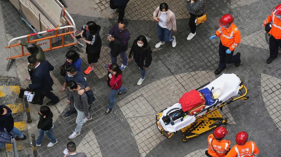 Seorang petugas pemadam kebakaran menyelamatkan orang-orang yang terjebak dari kebakaran yang terjadi di World Trade Center di Hong Kong (15/12/2021). (REUTERS/Lam Yik)