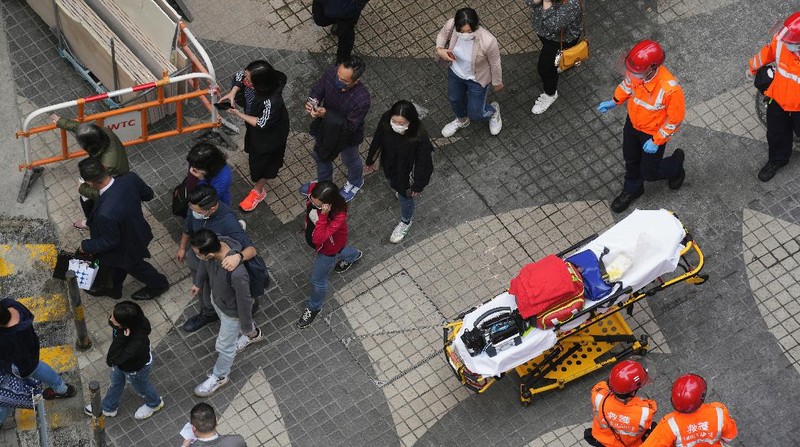 Seorang petugas pemadam kebakaran menyelamatkan orang-orang yang terjebak dari kebakaran yang terjadi di World Trade Center di Hong Kong (15/12/2021). (REUTERS/Lam Yik)