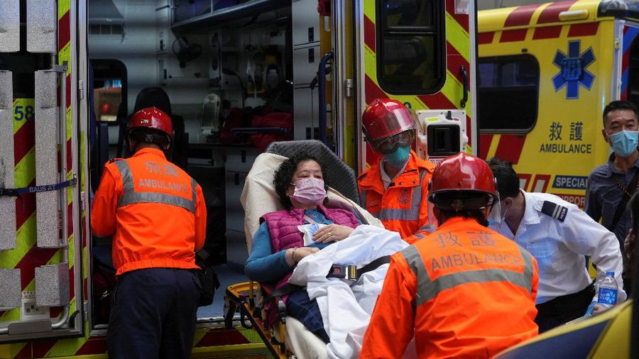 Seorang petugas pemadam kebakaran menyelamatkan orang-orang yang terjebak dari kebakaran yang terjadi di World Trade Center di Hong Kong (15/12/2021). (REUTERS/Lam Yik)