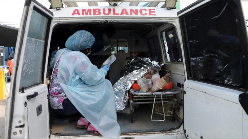 Warga berdiri di tengah rumah yang rusak akibat truk bensin terbalik dan meledak di Cap-Hatien, Haiti, Selasa (14/12/2021). Ledakan itu menghanguskan mobil dan rumah, menewaskan lebih dari 50 orang dan melukai puluhan lainnya. (AP/Joseph Odelyn)
