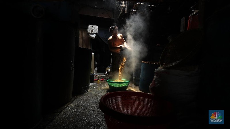 Suarso (68) menyelesaikan pembuatan tempe di kawasan Jakarta, Rabu (15/12/2021). Kementerian Perdagangan (Kemendag) memastikan, ketersediaan kedelai untuk bahan baku tempe dan tahu dalam negeri cukup untuk memenuhi kebutuhan Natal 2021 dan tahun baru 2022. Bahkan, Kemendag memperkirakan pasokan kedelai akan terjaga sampai kuartal I 2022.“Pasokan kedelai dari negara eksportir cukup baik. Saat ini negara produsen tengah memasuki masa panen, sehingga kami optimis pasokan kedelai akan cukup hingga kuartal pertama 2022,” kata Direktur Jenderal Perdagangan Luar Negeri, Oke Nurwan dikutip dari website resmi Kementerian Perdagangan.
Namun, ia tak merinci berapa jumlah pasokan kedelai yang tersedia saat ini. Ia hanya menyatakan dengan kecukupan pasokan itu, pihaknya memperkirakan harga kedelai stabil.
Sementara itu berdasarkan data Chicago Board of Trade (CBOT), harga kedelai dunia pada akhir November 2021 di sekitar USD12,17 per bushels atau setara USD446 per ton, turun dibanding awal Juni 2021 yang tercatat sebesar US$15,42 per bushel setara US$566 per ton.
