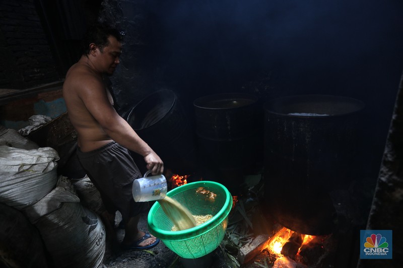 Suarso (68) menyelesaikan pembuatan tempe di kawasan Jakarta, Rabu (15/12/2021). Kementerian Perdagangan (Kemendag) memastikan, ketersediaan kedelai untuk bahan baku tempe dan tahu dalam negeri cukup untuk memenuhi kebutuhan Natal 2021 dan tahun baru 2022. Bahkan, Kemendag memperkirakan pasokan kedelai akan terjaga sampai kuartal I 2022.“Pasokan kedelai dari negara eksportir cukup baik. Saat ini negara produsen tengah memasuki masa panen, sehingga kami optimis pasokan kedelai akan cukup hingga kuartal pertama 2022,” kata Direktur Jenderal Perdagangan Luar Negeri, Oke Nurwan dikutip dari website resmi Kementerian Perdagangan.
Namun, ia tak merinci berapa jumlah pasokan kedelai yang tersedia saat ini. Ia hanya menyatakan dengan kecukupan pasokan itu, pihaknya memperkirakan harga kedelai stabil.
Sementara itu berdasarkan data Chicago Board of Trade (CBOT), harga kedelai dunia pada akhir November 2021 di sekitar USD12,17 per bushels atau setara USD446 per ton, turun dibanding awal Juni 2021 yang tercatat sebesar US$15,42 per bushel setara US$566 per ton.
