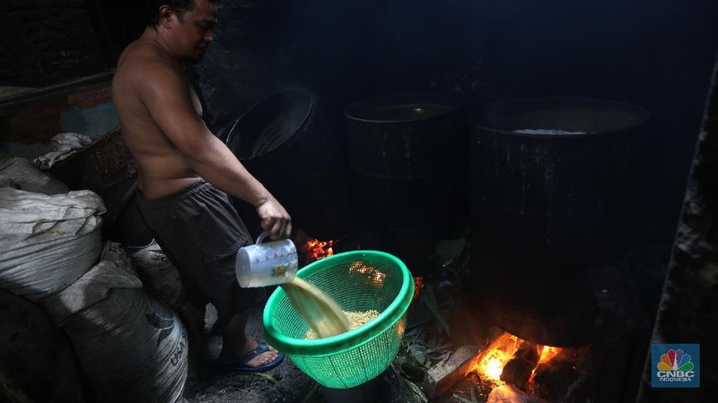 Suarso (68) menyelesaikan pembuatan tempe di kawasan Jakarta, Rabu (15/12/2021). Kementerian Perdagangan (Kemendag) memastikan, ketersediaan kedelai untuk bahan baku tempe dan tahu dalam negeri cukup untuk memenuhi kebutuhan Natal 2021 dan tahun baru 2022. Bahkan, Kemendag memperkirakan pasokan kedelai akan terjaga sampai kuartal I 2022.“Pasokan kedelai dari negara eksportir cukup baik. Saat ini negara produsen tengah memasuki masa panen, sehingga kami optimis pasokan kedelai akan cukup hingga kuartal pertama 2022,” kata Direktur Jenderal Perdagangan Luar Negeri, Oke Nurwan dikutip dari website resmi Kementerian Perdagangan.
Namun, ia tak merinci berapa jumlah pasokan kedelai yang tersedia saat ini. Ia hanya menyatakan dengan kecukupan pasokan itu, pihaknya memperkirakan harga kedelai stabil.
Sementara itu berdasarkan data Chicago Board of Trade (CBOT), harga kedelai dunia pada akhir November 2021 di sekitar USD12,17 per bushels atau setara USD446 per ton, turun dibanding awal Juni 2021 yang tercatat sebesar US$15,42 per bushel setara US$566 per ton.
