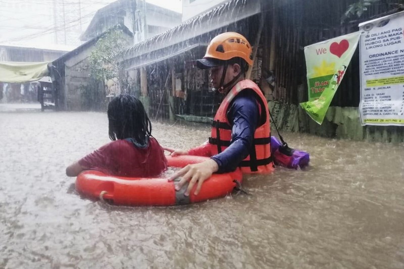Badai Topan Rai di Filipina Tim penyelamat membantu warga saat banjir yang disebabkan oleh Topan Rai saat mereka dievakuasi ke tempat yang lebih tinggi di Kota Cagayan de Oro, Filipina selatan, Kamis (16/12/2021). Puluhan ribu orang terdampar dievakuasi ke tempat yang aman di Filipina selatan dan tengah ketika Topan Rai mendekati Kamis pada saat pihak berwenang memperingatkan masyarakat untuk menghindari kerumunan setelah infeksi pertama yang disebabkan oleh jenis virus corona dilaporkan di negara itu, kata para pejabat. (Philippine Coast Guard via AP)