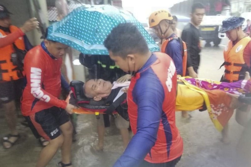Badai Topan Rai di Filipina Tim penyelamat membantu warga saat banjir yang disebabkan oleh Topan Rai saat mereka dievakuasi ke tempat yang lebih tinggi di Kota Cagayan de Oro, Filipina selatan, Kamis (16/12/2021). Puluhan ribu orang terdampar dievakuasi ke tempat yang aman di Filipina selatan dan tengah ketika Topan Rai mendekati Kamis pada saat pihak berwenang memperingatkan masyarakat untuk menghindari kerumunan setelah infeksi pertama yang disebabkan oleh jenis virus corona dilaporkan di negara itu, kata para pejabat. (Philippine Coast Guard via AP)
