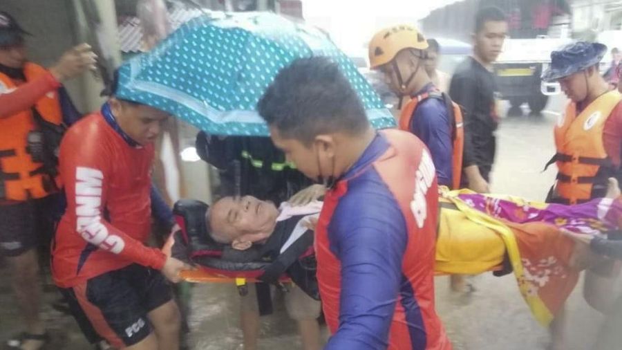 Tim penyelamat membantu warga saat banjir yang disebabkan oleh Topan Rai saat mereka dievakuasi ke tempat yang lebih tinggi di Kota Cagayan de Oro, Filipina selatan, Kamis (16/12/2021). Puluhan ribu orang terdampar dievakuasi ke tempat yang aman di Filipina selatan dan tengah ketika Topan Rai mendekati Kamis pada saat pihak berwenang memperingatkan masyarakat untuk menghindari kerumunan setelah infeksi pertama yang disebabkan oleh jenis virus corona dilaporkan di negara itu, kata para pejabat. (Philippine Coast Guard via AP)