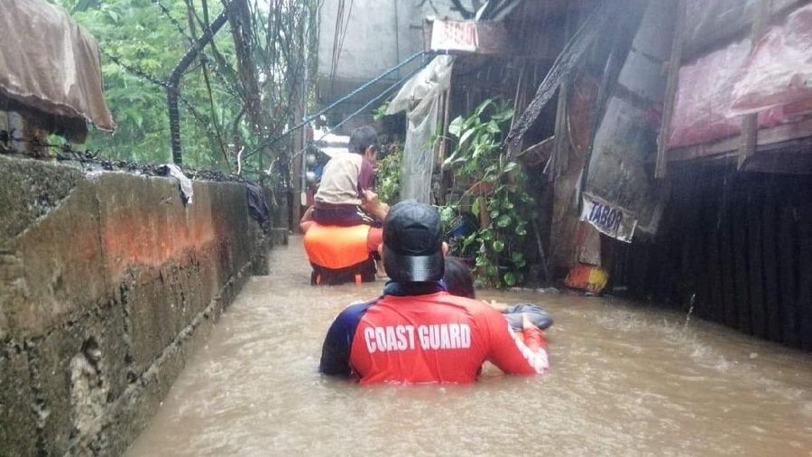 Tim penyelamat membantu warga saat banjir yang disebabkan oleh Topan Rai saat mereka dievakuasi ke tempat yang lebih tinggi di Kota Cagayan de Oro, Filipina selatan, Kamis (16/12/2021). Puluhan ribu orang terdampar dievakuasi ke tempat yang aman di Filipina selatan dan tengah ketika Topan Rai mendekati Kamis pada saat pihak berwenang memperingatkan masyarakat untuk menghindari kerumunan setelah infeksi pertama yang disebabkan oleh jenis virus corona dilaporkan di negara itu, kata para pejabat. (Philippine Coast Guard via AP)