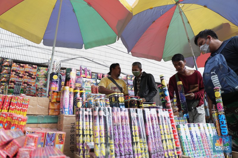 Pembeli memilih kembang api di Pasar Asemka, Jakarta, Kamis (16/12/2021). Sejumlah pedagang mengaku omzet penjualan kembang api tersebut menurun hingga 60 persen lebih karena adanya larangan berkerumun dan menggelar perayaan malam Tahun Baru 2022 sebagai pencegahan penyebaran virus COVID-19. Pantauan dilokasi, para pedagang menjajakan berbagai jenis kembang api di sepanjang kolong flyover Pasar Pagi hingga pinggir jalan. Salah satu pedagang, Idris (39) menyebut penjualan kembang api terus menurun pada tahun 2020, 2021 hingga 2022, biasanya 3 minggu sebelum tahun baru pesanan sudah mulai meningkat tapi sekarang belum ada karena ada PPKM dll