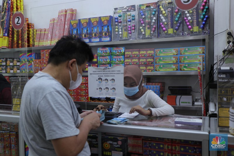 Pembeli memilih kembang api di Pasar Asemka, Jakarta, Kamis (16/12/2021). Sejumlah pedagang mengaku omzet penjualan kembang api tersebut menurun hingga 60 persen lebih karena adanya larangan berkerumun dan menggelar perayaan malam Tahun Baru 2022 sebagai pencegahan penyebaran virus COVID-19. Pantauan dilokasi, para pedagang menjajakan berbagai jenis kembang api di sepanjang kolong flyover Pasar Pagi hingga pinggir jalan. Salah satu pedagang, Idris (39) menyebut penjualan kembang api terus menurun pada tahun 2020, 2021 hingga 2022, biasanya 3 minggu sebelum tahun baru pesanan sudah mulai meningkat tapi sekarang belum ada karena ada PPKM dll