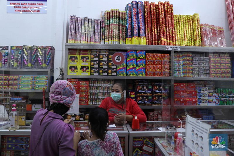 Pembeli memilih kembang api di Pasar Asemka, Jakarta, Kamis (16/12/2021). Sejumlah pedagang mengaku omzet penjualan kembang api tersebut menurun hingga 60 persen lebih karena adanya larangan berkerumun dan menggelar perayaan malam Tahun Baru 2022 sebagai pencegahan penyebaran virus COVID-19. Pantauan dilokasi, para pedagang menjajakan berbagai jenis kembang api di sepanjang kolong flyover Pasar Pagi hingga pinggir jalan. Salah satu pedagang, Idris (39) menyebut penjualan kembang api terus menurun pada tahun 2020, 2021 hingga 2022, biasanya 3 minggu sebelum tahun baru pesanan sudah mulai meningkat tapi sekarang belum ada karena ada PPKM dll