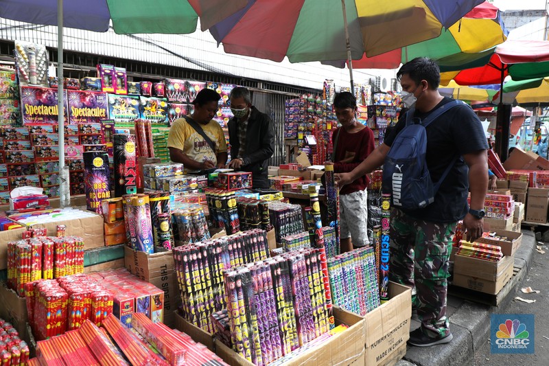 Pembeli memilih kembang api di Pasar Asemka, Jakarta, Kamis (16/12/2021). Sejumlah pedagang mengaku omzet penjualan kembang api tersebut menurun hingga 60 persen lebih karena adanya larangan berkerumun dan menggelar perayaan malam Tahun Baru 2022 sebagai pencegahan penyebaran virus COVID-19. Pantauan dilokasi, para pedagang menjajakan berbagai jenis kembang api di sepanjang kolong flyover Pasar Pagi hingga pinggir jalan. Salah satu pedagang, Idris (39) menyebut penjualan kembang api terus menurun pada tahun 2020, 2021 hingga 2022, biasanya 3 minggu sebelum tahun baru pesanan sudah mulai meningkat tapi sekarang belum ada karena ada PPKM dll