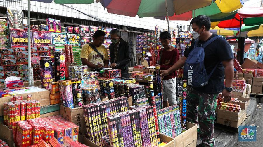 Pembeli memilih kembang api di Pasar Asemka, Jakarta, Kamis (16/12/2021). Sejumlah pedagang mengaku omzet penjualan kembang api tersebut menurun hingga 60 persen lebih karena adanya larangan berkerumun dan menggelar perayaan malam Tahun Baru 2022 sebagai pencegahan penyebaran virus COVID-19. Pantauan dilokasi, para pedagang menjajakan berbagai jenis kembang api di sepanjang kolong flyover Pasar Pagi hingga pinggir jalan. Salah satu pedagang, Idris (39) menyebut penjualan kembang api terus menurun pada tahun 2020, 2021 hingga 2022, biasanya 3 minggu sebelum tahun baru pesanan sudah mulai meningkat tapi sekarang belum ada karena ada PPKM dll