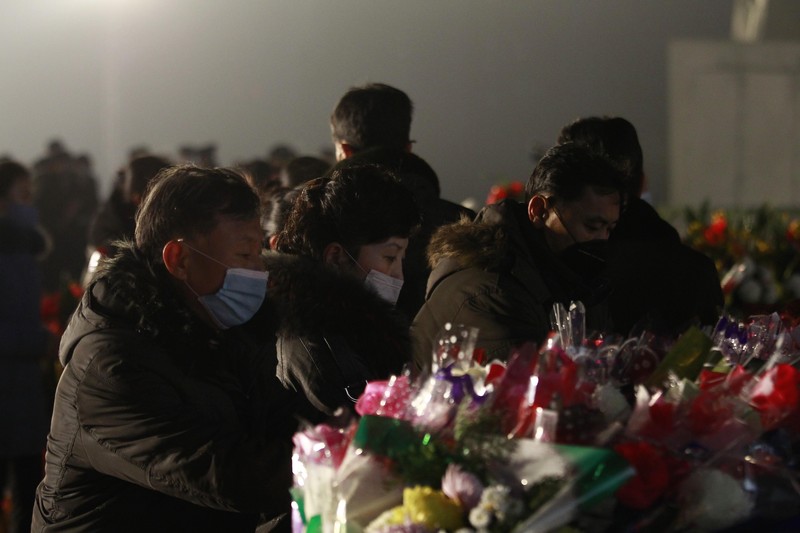 Warga mengunjungi patung perunggu mendiang pemimpin mereka Kim Il Sung, kiri, dan Kim Jong Il dalam rangka peringatan 10 tahun kematian Kim Jong Il di Bukit Mansu di Pyongyang, Korea Utara, Kamis (16/12/2021). (AP/Cha Song Ho)