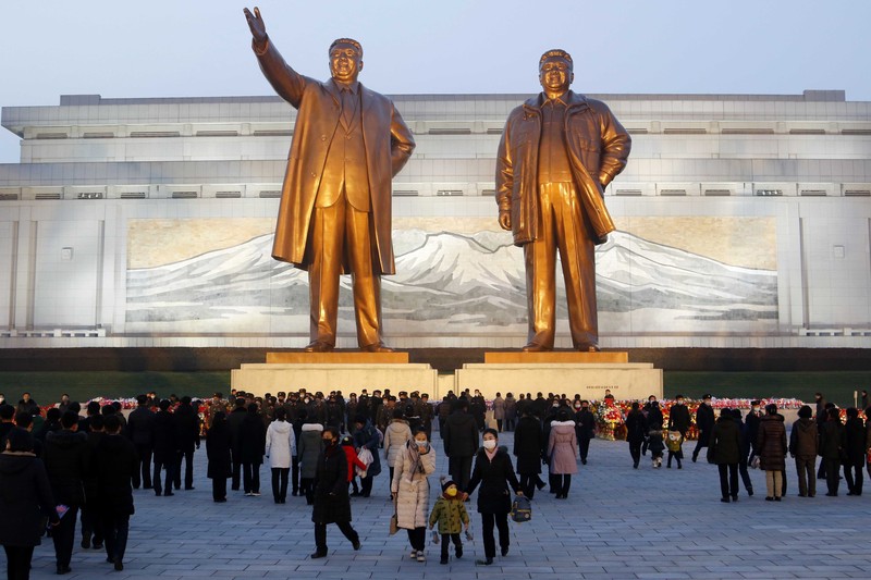 Warga mengunjungi patung perunggu mendiang pemimpin mereka Kim Il Sung, kiri, dan Kim Jong Il dalam rangka peringatan 10 tahun kematian Kim Jong Il di Bukit Mansu di Pyongyang, Korea Utara, Kamis (16/12/2021). (AP/Cha Song Ho)