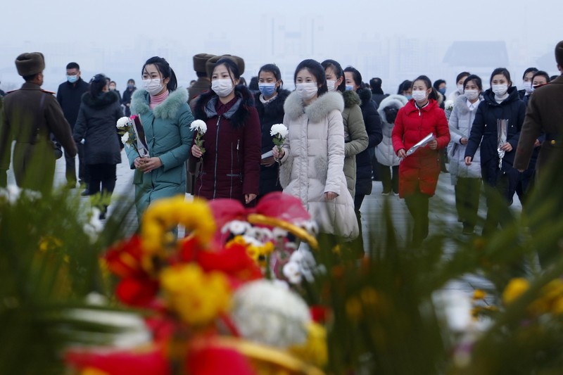 Warga mengunjungi patung perunggu mendiang pemimpin mereka Kim Il Sung, kiri, dan Kim Jong Il dalam rangka peringatan 10 tahun kematian Kim Jong Il di Bukit Mansu di Pyongyang, Korea Utara, Kamis (16/12/2021). (AP/Cha Song Ho)