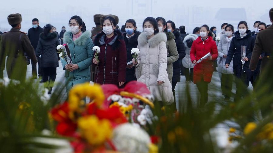 Warga mengunjungi patung perunggu mendiang pemimpin mereka Kim Il Sung, kiri, dan Kim Jong Il dalam rangka peringatan 10 tahun kematian Kim Jong Il di Bukit Mansu di Pyongyang, Korea Utara, Kamis (16/12/2021). (AP/Cha Song Ho)