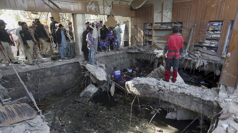 Tim penyelamat memeriksa lokasi ledakan gas di Karachi, Pakistan, Sabtu, 18 Desember 2021. Ledakan gas yang kuat di sistem pembuangan limbah di kota Pakistan selatan menewaskan beberapa orang dan melukai lainnya. (AP/Fareed Khan)