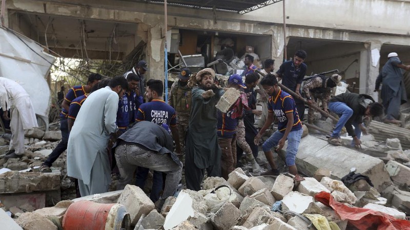 Tim penyelamat memeriksa lokasi ledakan gas di Karachi, Pakistan, Sabtu, 18 Desember 2021. Ledakan gas yang kuat di sistem pembuangan limbah di kota Pakistan selatan menewaskan beberapa orang dan melukai lainnya. (AP/Fareed Khan)