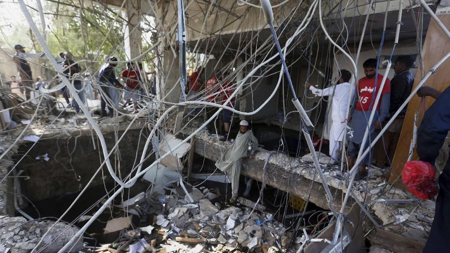 Tim penyelamat memeriksa lokasi ledakan gas di Karachi, Pakistan, Sabtu, 18 Desember 2021. Ledakan gas yang kuat di sistem pembuangan limbah di kota Pakistan selatan menewaskan beberapa orang dan melukai lainnya. (AP/Fareed Khan)