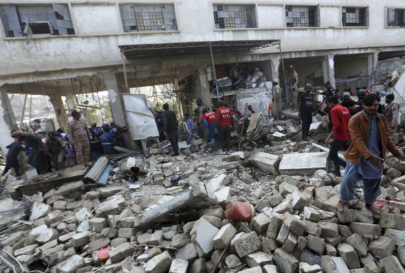 Tim penyelamat memeriksa lokasi ledakan gas di Karachi, Pakistan, Sabtu, 18 Desember 2021. Ledakan gas yang kuat di sistem pembuangan limbah di kota Pakistan selatan menewaskan beberapa orang dan melukai lainnya. (AP/Fareed Khan)