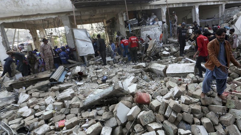 Tim penyelamat memeriksa lokasi ledakan gas di Karachi, Pakistan, Sabtu, 18 Desember 2021. Ledakan gas yang kuat di sistem pembuangan limbah di kota Pakistan selatan menewaskan beberapa orang dan melukai lainnya. (AP/Fareed Khan)