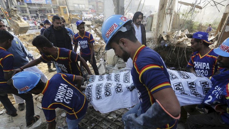 Tim penyelamat memeriksa lokasi ledakan gas di Karachi, Pakistan, Sabtu, 18 Desember 2021. Ledakan gas yang kuat di sistem pembuangan limbah di kota Pakistan selatan menewaskan beberapa orang dan melukai lainnya. (AP/Fareed Khan)