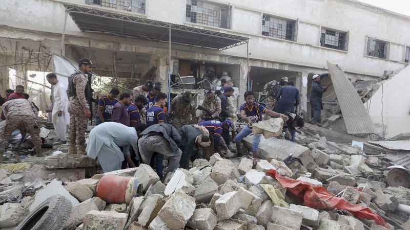 Tim penyelamat memeriksa lokasi ledakan gas di Karachi, Pakistan, Sabtu, 18 Desember 2021. Ledakan gas yang kuat di sistem pembuangan limbah di kota Pakistan selatan menewaskan beberapa orang dan melukai lainnya. (AP/Fareed Khan)