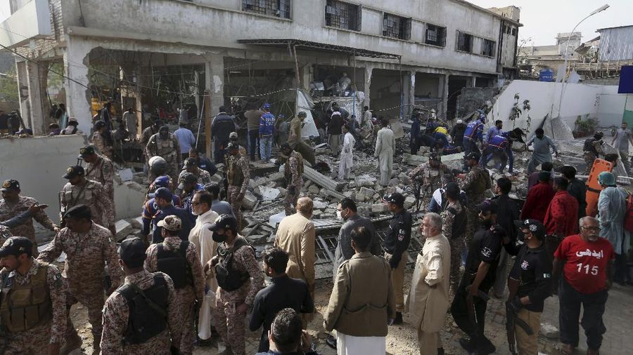 Tim penyelamat memeriksa lokasi ledakan gas di Karachi, Pakistan, Sabtu, 18 Desember 2021. Ledakan gas yang kuat di sistem pembuangan limbah di kota Pakistan selatan menewaskan beberapa orang dan melukai lainnya. (AP/Fareed Khan)