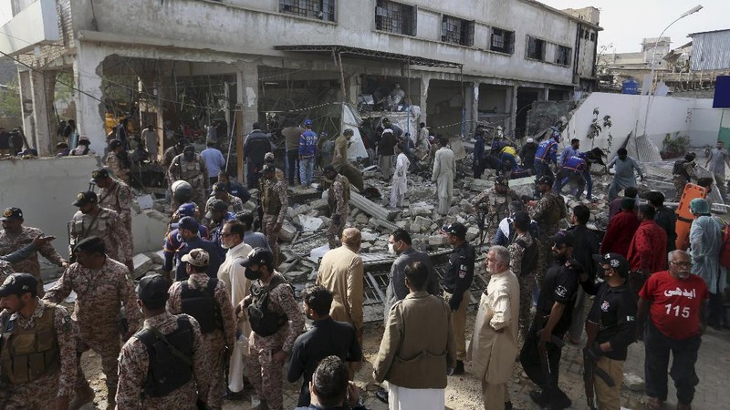 Tim penyelamat memeriksa lokasi ledakan gas di Karachi, Pakistan, Sabtu, 18 Desember 2021. Ledakan gas yang kuat di sistem pembuangan limbah di kota Pakistan selatan menewaskan beberapa orang dan melukai lainnya. (AP/Fareed Khan)