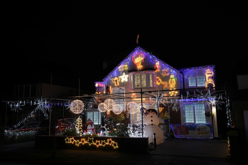 Orang-orang berjalan di jembatan saat lampu Natal menerangi Darsena dei Navigli, lingkungan yang dinamai kanal yang melintasi area Milan, Italia. (AP Photo/Luca Bruno)