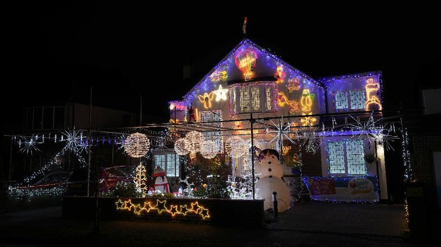 Orang-orang berjalan di jembatan saat lampu Natal menerangi Darsena dei Navigli, lingkungan yang dinamai kanal yang melintasi area Milan, Italia. (AP Photo/Luca Bruno)