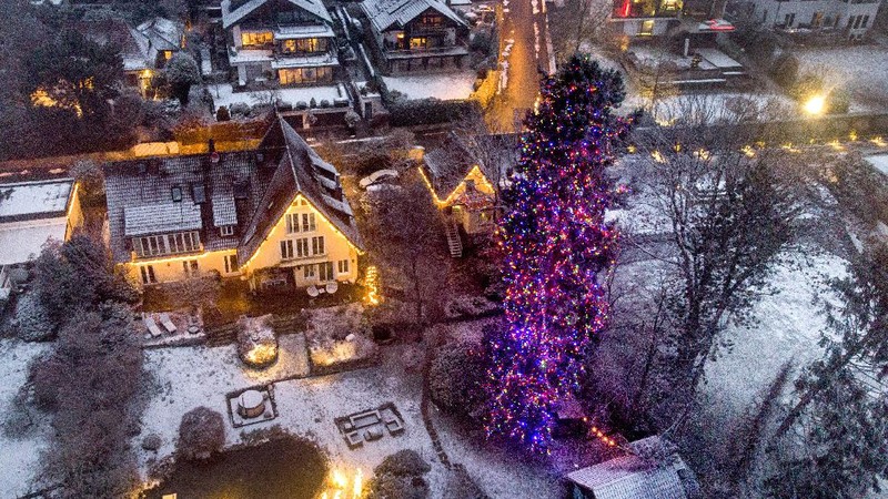 Orang-orang berjalan di jembatan saat lampu Natal menerangi Darsena dei Navigli, lingkungan yang dinamai kanal yang melintasi area Milan, Italia. (AP Photo/Luca Bruno)