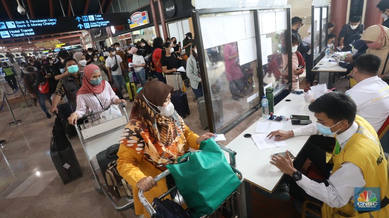 Puluhan penumpang mengantre di loket validasi syarat berkas kesehatan penumpang di Terminal 2 Keberangkatan Domestik, Bandara Soekarno-Hatta, Tangerang, Jumat (24/12/2021). (CNBC Indonesia/Andrean Kristianto)