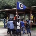 Warga memegang bendera Bougainville di tempat pemungutan suara selama referendum kemerdekaan yang tidak mengikat di Arawa, di pulau Bougainville, Papua Nugini, (26/19). (REUTERS/Melvin Levongo/File Foto)