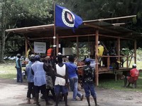 Warga memegang bendera Bougainville di tempat pemungutan suara selama referendum kemerdekaan yang tidak mengikat di Arawa, di pulau Bougainville, Papua Nugini, (26/19). (REUTERS/Melvin Levongo/File Foto)