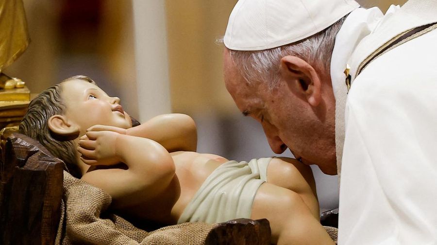 Pope Francis kisses a statue of baby Jesus as he celebrates Christmas Eve Holy Mass in St. Peter's Basilica at the Vatican, December 24, 2021. REUTERS/Guglielmo Mangiapane     TPX IMAGES OF THE DAY